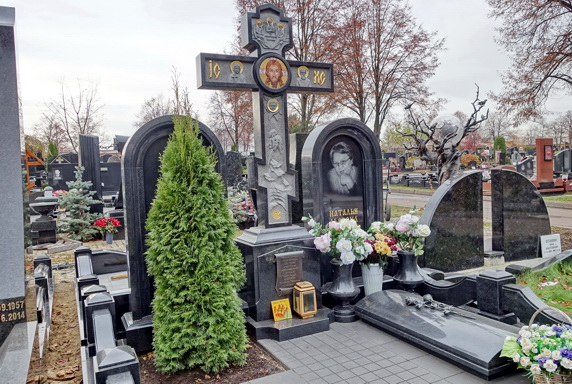 Покрытый резьбой православный крест и туя на клумбе без бортов